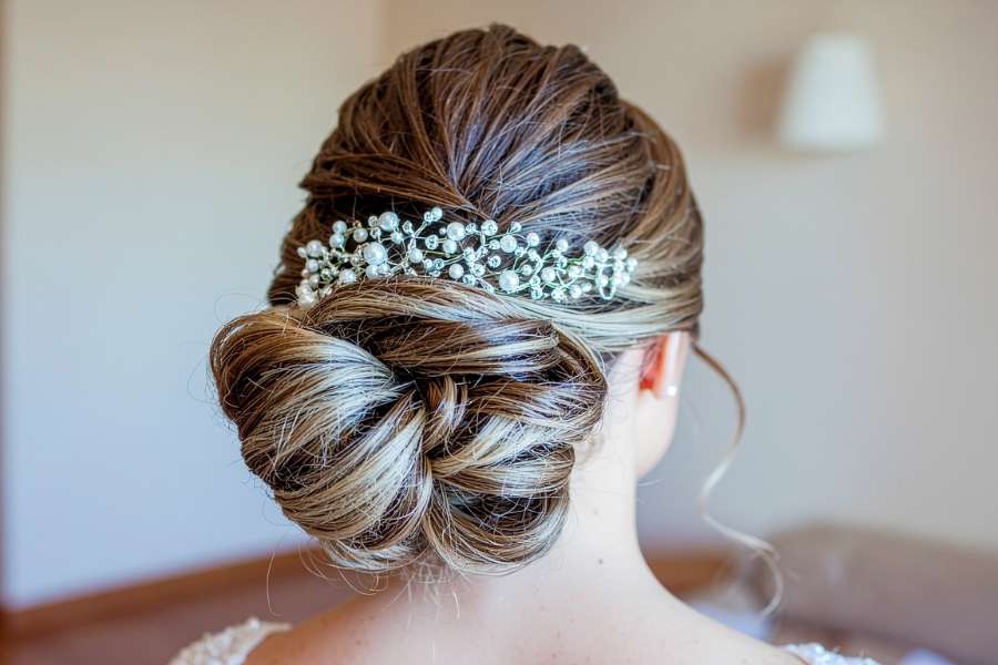 Un magnifique chignon bas élégant et orné d'un bijou étincelant pour une coiffure de mariée réussie.